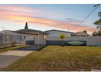 Charming single-story home featuring a carport and well-maintained lawn at sunset at 6816 Sanderling Ln, Hudson, FL 34667