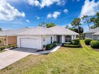 Charming single-story home with a well-maintained lawn, mature landscaping, and an attached two-car garage at 9237 Penelope Dr, Weeki Wachee, FL 34613