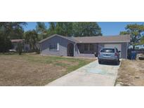 Charming home featuring a stucco exterior, well-maintained lawn, and convenient driveway parking at 10347 Caspian St, Spring Hill, FL 34608