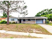 Charming single-story home featuring a cozy front porch and attached garage at 1919 Harpoon Dr, Holiday, FL 34690