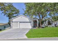 Charming single-Gathering home with a well-manicured lawn, mature trees, and a two-car garage at 2327 Morning Glory Trl, Spring Hill, FL 34606