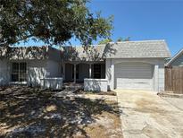 Charming single-story home featuring an attached garage, a brick walkway, and mature landscaping at 3617 Rockaway Dr, Holiday, FL 34691