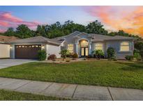 Charming single-story home with manicured lawn and well-maintained landscaping at sunset at 4080 Gevalia Dr, Brooksville, FL 34604