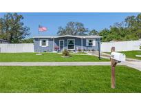 Charming single-story home with a well-manicured lawn, an American flag and a picket fence at 447 Briarwood Ln, Spring Hill, FL 34606