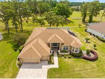 Beautiful home featuring mature landscaping, a screened pool, and a brick paver driveway and entryway at 5164 Golf Club Ln, Spring Hill, FL 34609