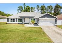 Charming single-story home featuring a well-manicured lawn and attached two-car garage at 5341 Birchwood Rd, Spring Hill, FL 34608
