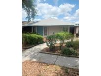 Charming single-story home featuring a landscaped front yard with lush greenery and a well-maintained walkway at 8008 La Serena Dr, Tampa, FL 33614