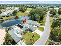Aerial view of a well-maintained single-Gathering home next to a pond with a screened in pool at 9010 Penelope Dr, Weeki Wachee, FL 34613