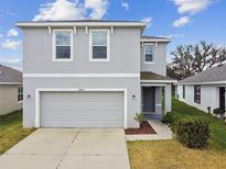 Two-story home featuring a two-car garage and freshly landscaped yard at 10823 Penny Gale Loop, San Antonio, FL 33576