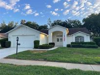 Charming single-story home with a well-maintained lawn, double door entry, and attached two-car garage at 11213 Brooklawn Dr, Hudson, FL 34667