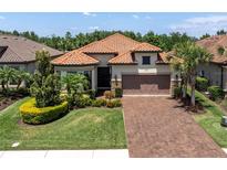 Beautiful single-story home with a tile roof, well-manicured lawn, and a brick driveway at 11325 Juglans Dr, Odessa, FL 33556
