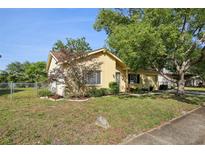 Charming single-story home with a well-maintained lawn, landscaping, and a fenced yard at 12906 Sandburst Ln, Hudson, FL 34667