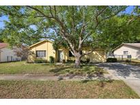 Charming single-story home featuring a well-manicured lawn and mature trees at 12906 Sandburst Ln, Hudson, FL 34667