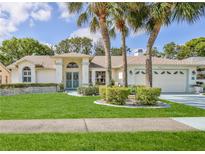 Charming single-story home with well-manicured lawn and lush landscaping at 1496 Overland Dr, Spring Hill, FL 34608