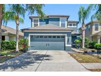 Charming two-story home with a well-maintained lawn and a spacious two-car garage with lush landscaping at 18061 Glastonbury Ln, Land O Lakes, FL 34638