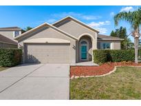 Charming single-Gathering home featuring a well-kept lawn, front shrubs, and an attached two-car garage at 1810 Winsloe Dr, Trinity, FL 34655