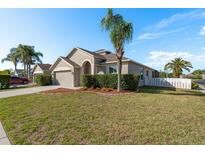 Charming single-story home with well-maintained landscaping, attached garage, and inviting curb appeal under a clear blue sky at 1810 Winsloe Dr, Trinity, FL 34655
