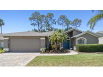 Well-maintained single-story home featuring an attached two-car garage and a beautifully landscaped front yard at 18532 Myrtlewood Dr, Hudson, FL 34667