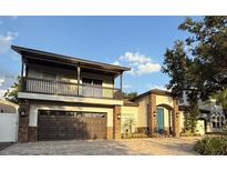 Beautiful two-story home with a covered balcony, stone accents, and a paved driveway at 210 S Hale Ave, Tampa, FL 33609