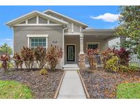 Charming single-story home features a landscaped front yard and covered porch with stone accents at 21167 Pleasant Plains Pkwy, Land O Lakes, FL 34637