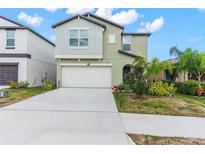Charming two-story home featuring a well-manicured lawn, two-car garage, and appealing architectural details at 2132 Shining Azul Way, Lutz, FL 33558