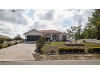 Charming single-story home with a well-manicured front yard, long driveway, and attached two-car garage at 3102 Lema Dr, Spring Hill, FL 34609