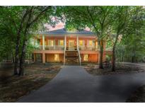 Charming two-story home featuring a wraparound porch, classic design, and lush, mature landscaping at 3431 Riderwood Dr, Dade City, FL 33523