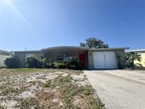 Charming single-story home featuring a red front door and attached garage on a sunny day at 5316 Drift Tide Dr, New Port Richey, FL 34652