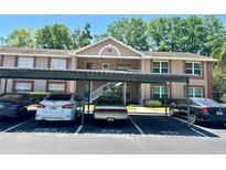 Inviting condo building with covered parking, neat landscaping, and a classic architectural design at 6410 Spring Flower Dr # 26, New Port Richey, FL 34653