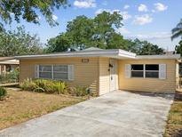 Charming single-story home with a well-maintained front yard and a classic yellow siding at 7012 Ponderosa Dr, Tampa, FL 33637