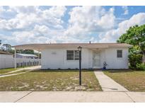 Charming single-story home with a covered carport, neatly kept lawn, and neutral color scheme at 7050 Merrick Ln, Spring Hill, FL 34606