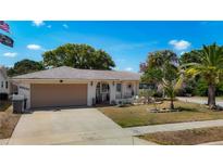 Charming single-story home featuring a two-car garage, well-maintained landscaping, and a welcoming front entrance at 8600 N Briar Patch Dr, Port Richey, FL 34668