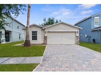Charming single-story home featuring a paved driveway, two-car garage, and well-maintained lawn at 3410 Thistledown Ln, Land O Lakes, FL 34638