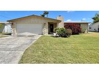 Charming single-story home featuring an attached garage and a well-maintained lawn with attractive landscaping at 4333 Baden Dr, Holiday, FL 34691