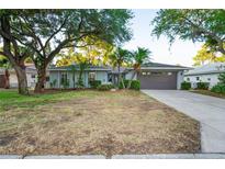Charming single-story home featuring mature trees, well-kept landscaping, and a two-car garage at 4369 Marine Pkwy, New Port Richey, FL 34652