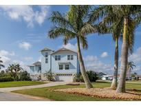 Inviting two-story home with attached garage, lush landscaping, and towering palm trees at 5040 Waterside Dr, Port Richey, FL 34668