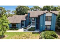 A charming exterior view of townhomes with lush landscaping and bright blue facade at 7644 St Andrews Blvd # 0, Weeki Wachee, FL 34613