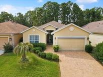 Charming single-story home featuring a two-car garage, brick driveway, and a well-manicured front yard at 10187 Holly Berry Dr, Weeki Wachee, FL 34613