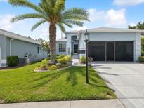 Charming single-story home with well-manicured lawn, lush landscaping, and a decorative palm tree at 11342 Hollander Ave, Hudson, FL 34667
