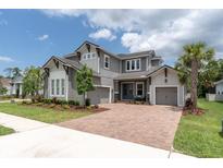 Charming two-story home with a brick driveway, three-car garage, and mature landscaping at 12539 Wetmore Ct, Odessa, FL 33556