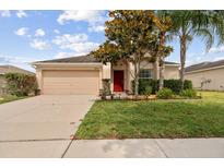 Charming single-story home with a well-manicured lawn and a two-car garage at 18710 Dobson Dr, Hudson, FL 34667