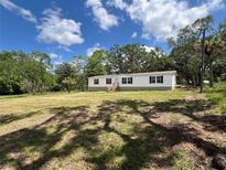 Lovely single-story home featuring a large front yard and shaded by mature trees at 20064 Manecke Rd, Brooksville, FL 34601