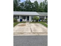 Charming townhome featuring a light gray roof, gray shutters, and a concrete parking pad at 2850 Westmoreland Ct, New Port Richey, FL 34655