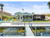 Waterfront home featuring a private dock, a cozy screened-in porch, and scenic water views at 4128 Camelia Dr, Hernando Beach, FL 34607