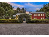 Unique multi-section home with colorful exteriors and manicured greenery creates a striking and inviting curb appeal at 4541 School Rd, Land O Lakes, FL 34638