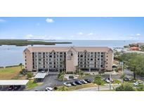 Stunning condo exterior showcasing meticulously maintained landscaping, covered parking, and serene waterfront views at 4550 Bay Blvd # 1231, Port Richey, FL 34668