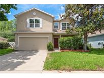 Charming two-story home featuring a well-manicured lawn and a two-car garage at 6125 Desert Peace Ave, Land O Lakes, FL 34639