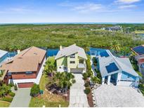 Waterfront home featuring lush tropical landscaping, open floor plan, balcony, and views of the mangroves and ocean at 6321 Garland Ct, New Port Richey, FL 34652