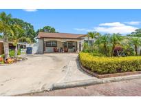 Charming single-story home with well-manicured landscaping, lush plants and concrete driveway at 713 715 W Fribley St, Tampa, FL 33603