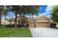 Charming single-story home with a well-manicured lawn, mature trees, and a spacious three-car garage at 9124 Topneck St, New Port Richey, FL 34654